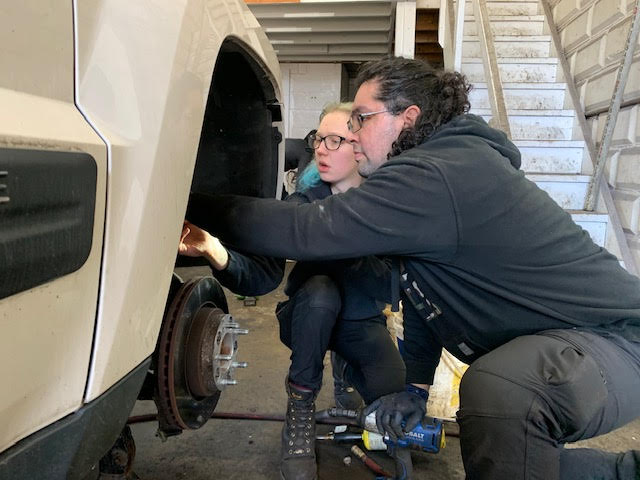 Sebastian Sanchez and Lauren Davidson working on a car